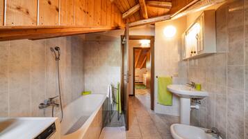 A modern bathroom with a bathtub, sink, and shower.