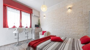 Une chambre d’hôtel moderne équipée d’un lit, d’un bureau et de deux tabourets de bar.