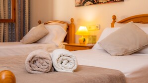 A hotel room with a bed, pillows, a lamp, and a painting of the Eiffel Tower. - Chalet Villa Can Jaume with Wi-Fi, A/C, Terraces & Garden; Pet-Friendly (puerto alcudia)