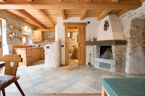 Une cuisine rustique avec des poutres en bois, des murs en pierre et une cheminée.
