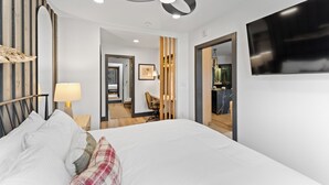 A modern hotel room with a large bed, a ceiling fan, a TV, and a wooden accent wall. - Silver Mill #8162 by Summit County Mountain Retreats (Keystone)