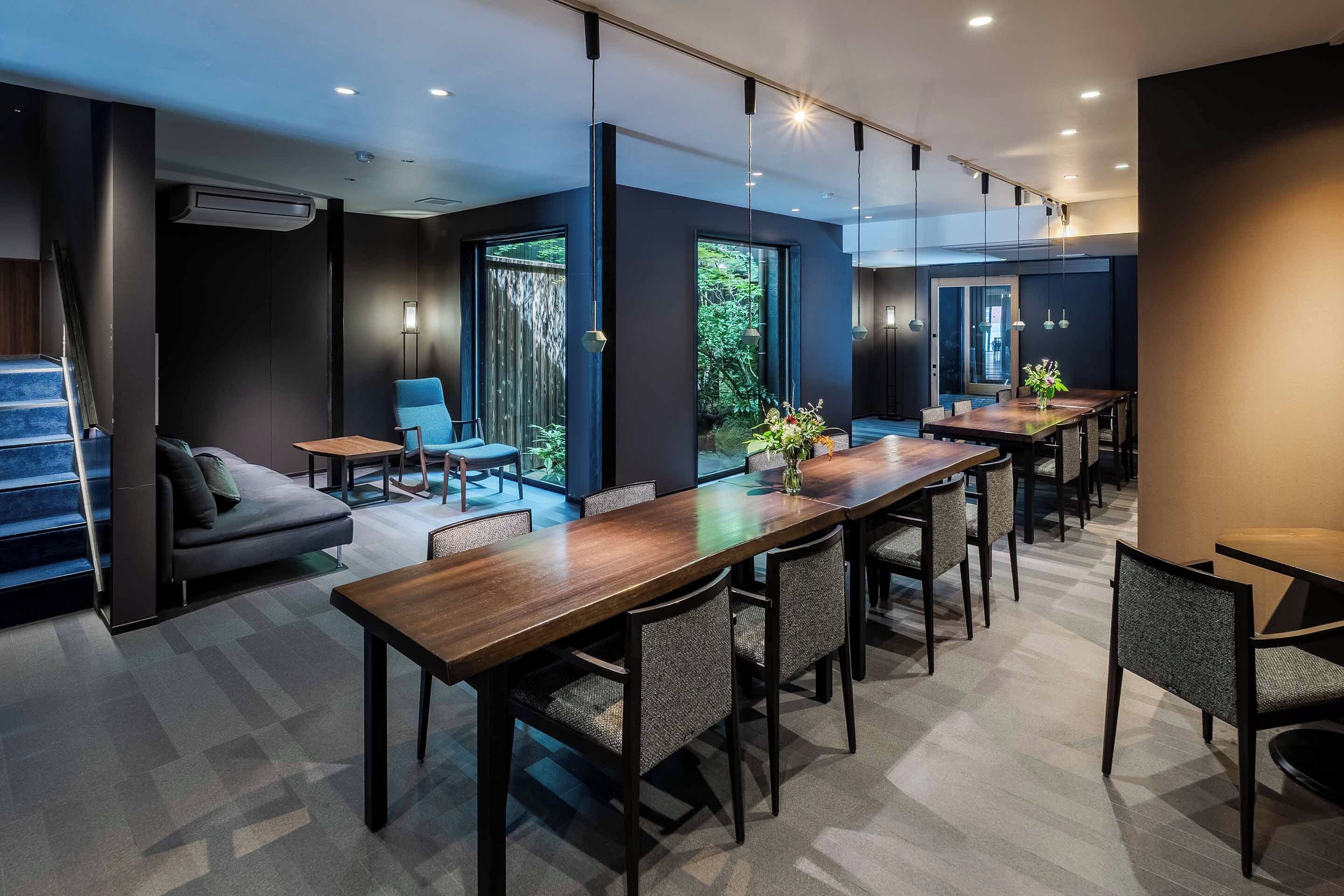 A modern conference room with a long table, chairs, and a sofa.