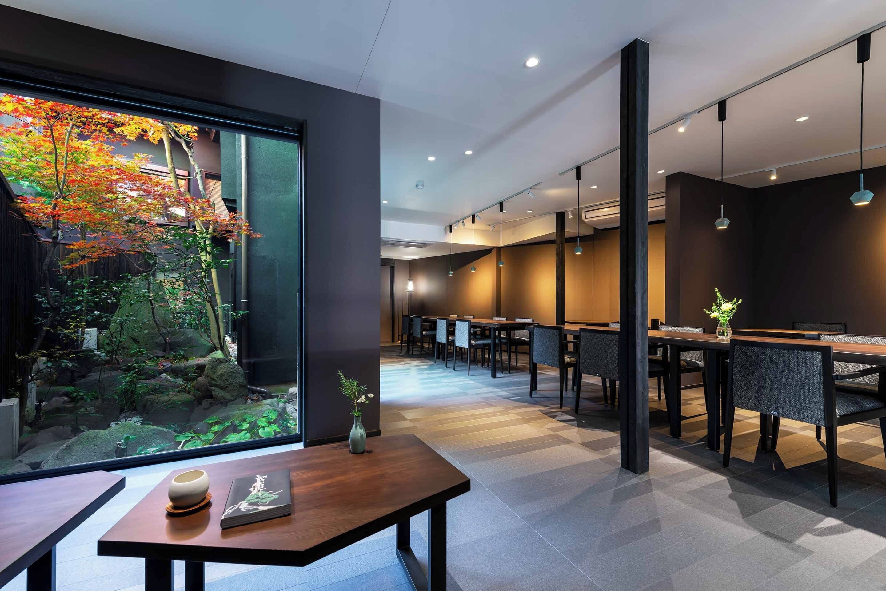 A modern dining area with a view of a garden through a large window.