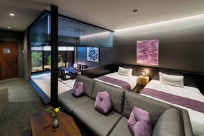 Een moderne hotelkamer met een bank, een bed, een bureau en uitzicht op het landschap.