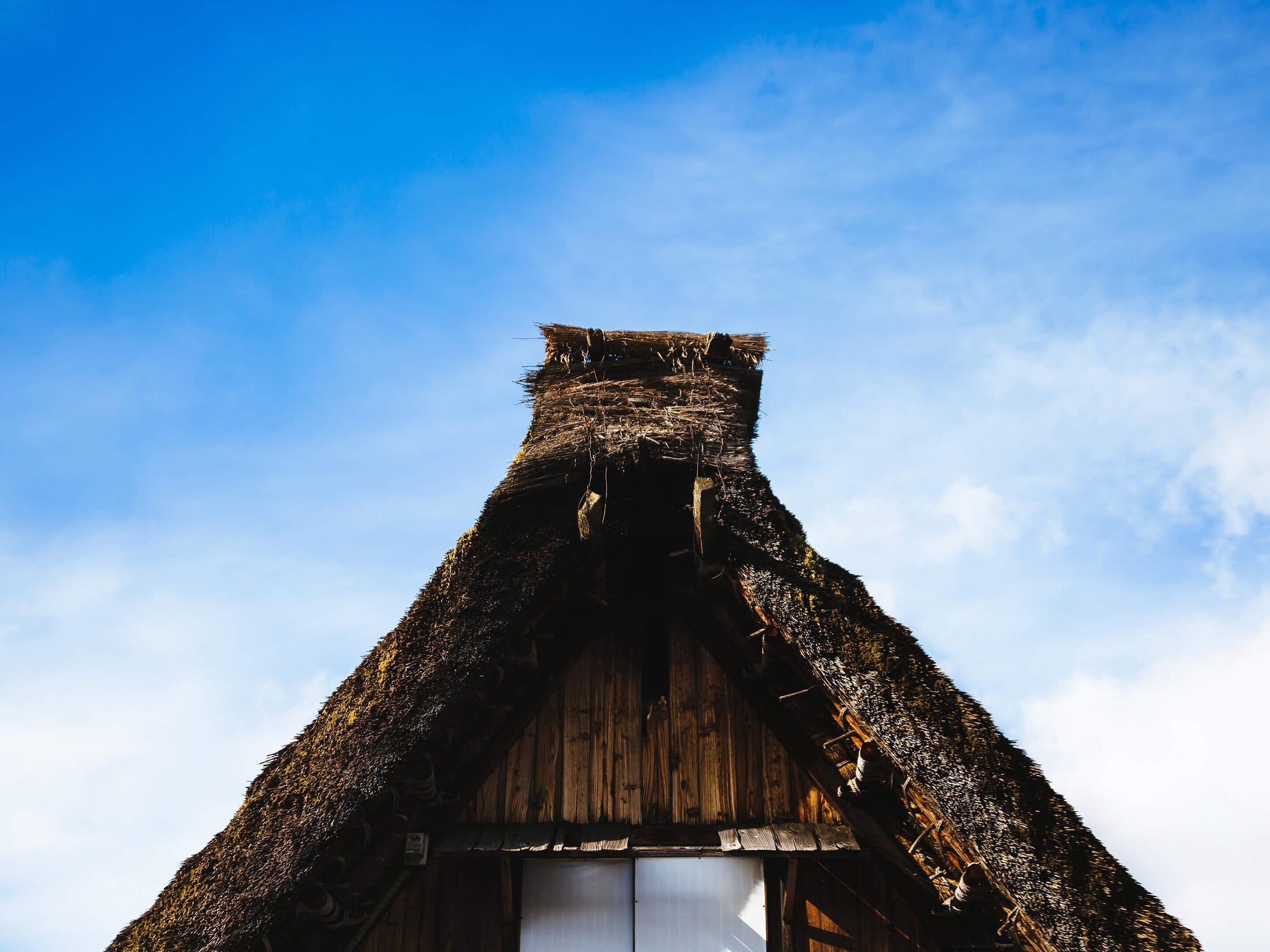 A traditional thatched-roof building with a wooden door and a small window.