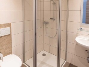 A bathroom with a glass-enclosed shower, a white sink, and a toilet. - Tilda - Schöbringer Farm (Miglberg)