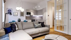 Una sala de estar moderna con un sofá, una mesa de centro y un comedor con sillas.