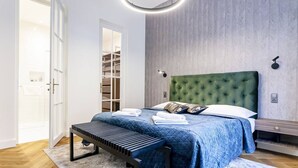Un dormitorio con cama, banco, mesita de noche y armario.