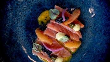 A blue ceramic plate with a seafood dish.