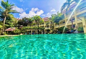 A hotel with a pool, palm trees, and a clear blue sky. - Krabi Success Beach Resort (Krabi)