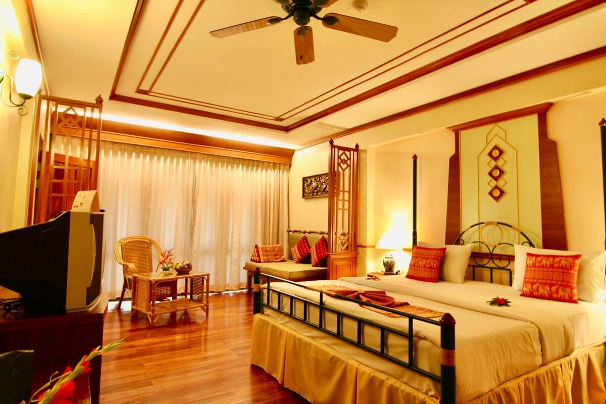 A hotel room with a bed, a television, a desk, and a chair.