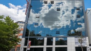 A modern hotel building with a glass facade reflecting clouds and sky. - Corlu Dem Hotel (Corlu)
