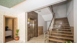 A modern interior with a marble staircase, a kitchen area, and a potted plant. - Corlu Dem Hotel (Corlu)