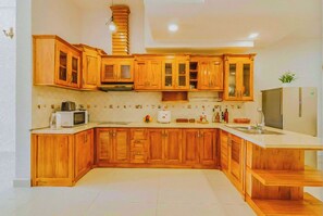 Enjoy cooking in this well-equipped kitchen with appliances, a sink, and a refrigerator.