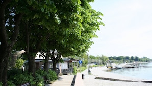 A waterfront promenade with benches, a pedestrian path, and a boat dock. - Direttamente Sulla Spiaggia, Vista Lago Impareggiabile (Moniga del Garda)