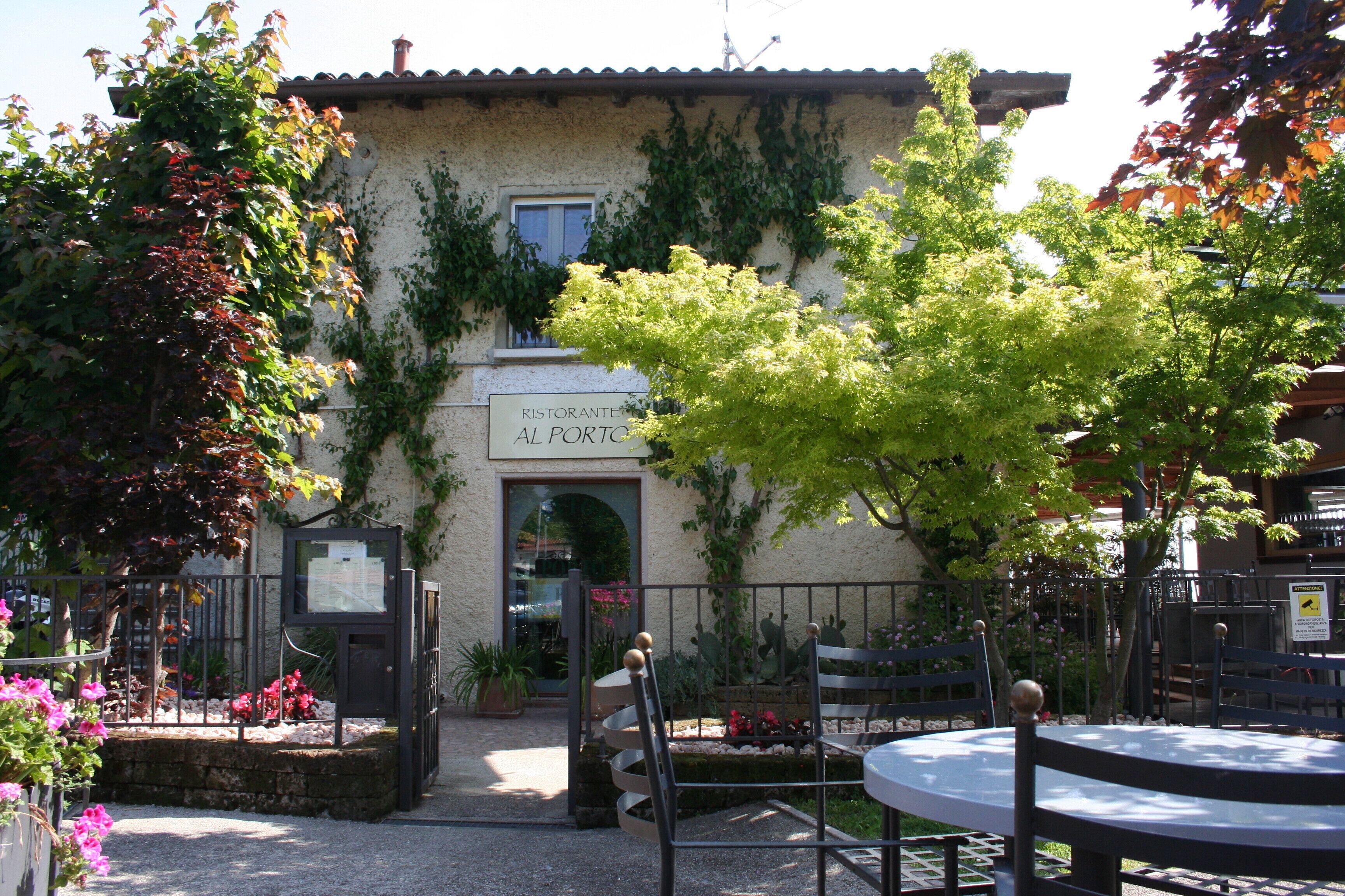 A building with a sign reading 'Ristorante Al Porto' and a gated entrance.