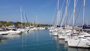 A marina with multiple sailboats docked in calm waters. - Direttamente Sulla Spiaggia con Terrazza Vista Lago (Moniga del Garda)