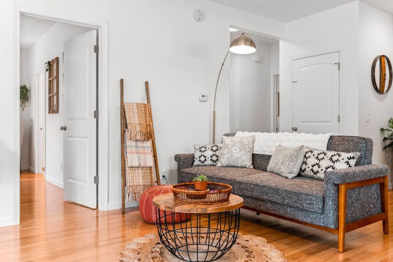 A living room with a grey sofa, a round coffee table, and a floor lamp.