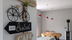 A wall with signs reading "Bistro," "Cafe," and "DASSERIE," and a bicycle. - Charming Countryside Retreat with Modern Comforts near Hiking Trails and Lakes (Uriménil)