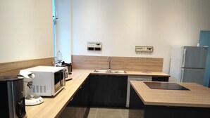 A modern kitchen with a microwave, coffee maker, and a sink. - Charming Countryside Retreat with Modern Comforts near Hiking Trails and Lakes (Uriménil)