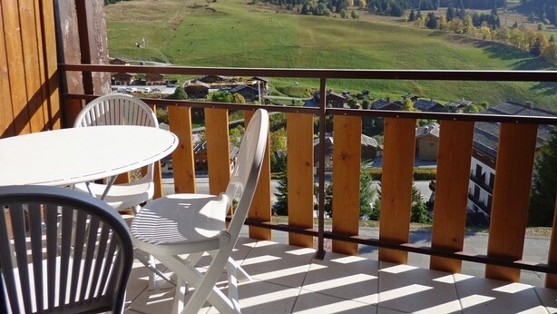 A balcony with a view of a mountain, a table, and two chairs. - Bright Savoyard studio with south-facing balcony (Le Grand-Bornand)