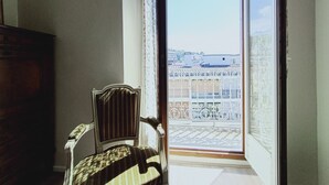 A room with a view of a balcony and buildings.