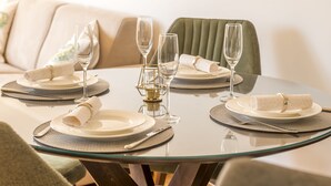 A dining table set with plates, glasses, and a centerpiece. - Cicciobello Lux Apartment with stunning sea view (Baošići)