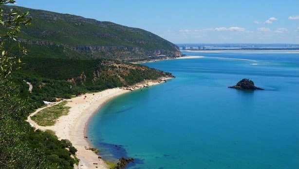 A coastal landscape with a beach, clear blue waters, and a hill with greenery. - Perfect for quiet vacation with family and friends (Setúbal)