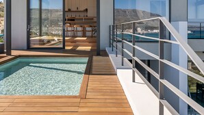 Un bâtiment moderne doté d’une piscine, de grandes fenêtres et offrant une vue sur le paysage.