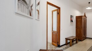 Ein Flur mit einer Holztür, einem kleinen Tisch mit einer Schüssel und einem Schrank.