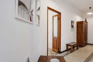 A hallway with a wooden door, a small table with a bowl, and a cabinet.