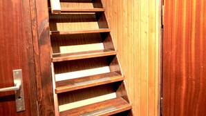 Eine hölzerne Wendeltreppe mit Metallgeländern, die zu einer oberen Etage führt.