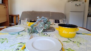 Een eettafel gedekt met borden, bestek en een gele pot met de tekst 'Les moutons'.