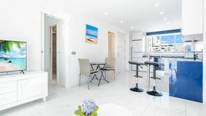 A modern kitchen with a large island, white cabinetry, and a view of the city. - Don Paco 12-B Deluxe Apartment Levante Beach (Benidorm)