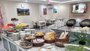 A buffet setup with various food items and utensils. - GRAND PA Hotel&Resort Lamphun Chiang Mai (Lamphun)