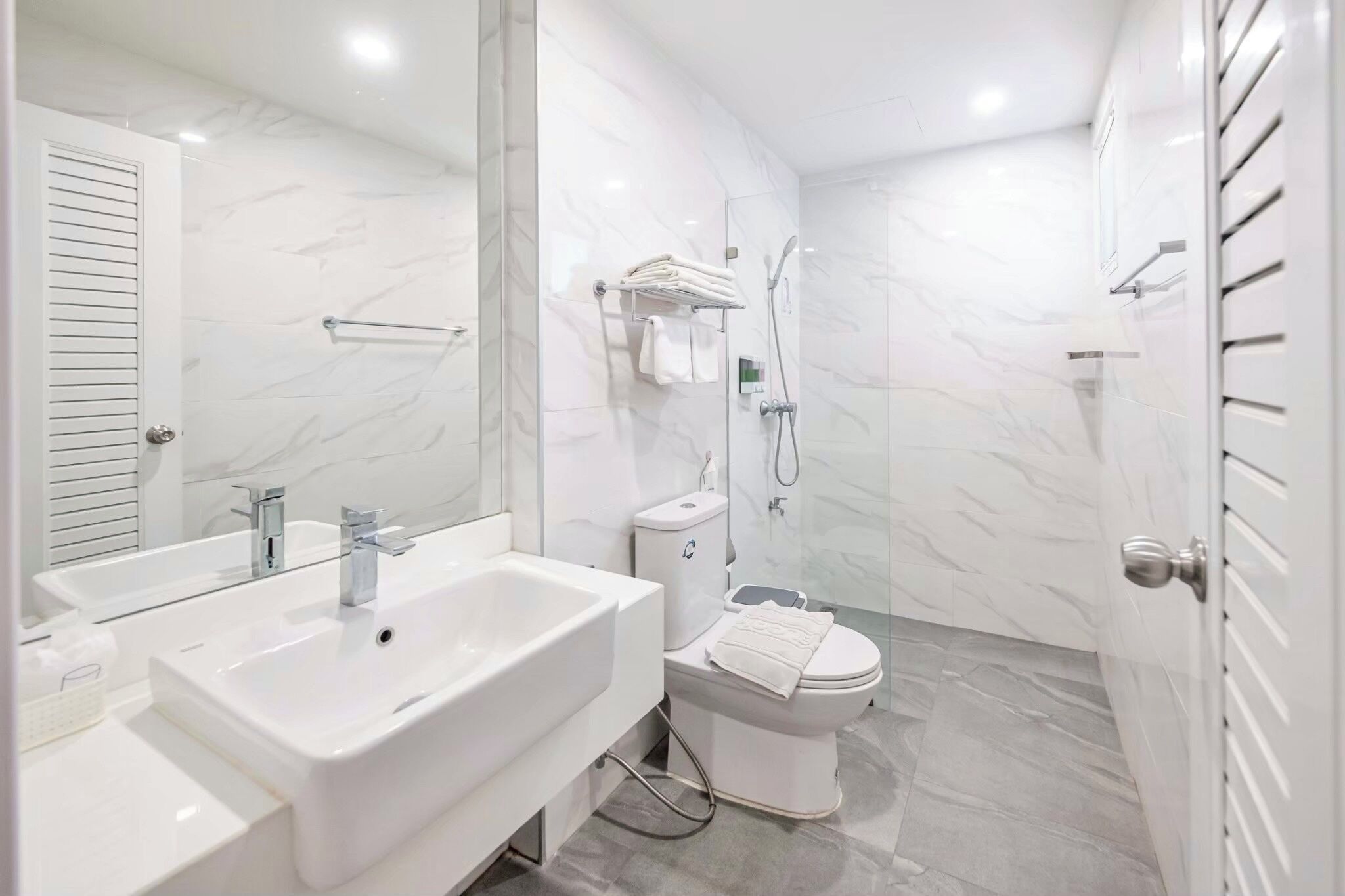A modern bathroom with a large sink, toilet, and shower.