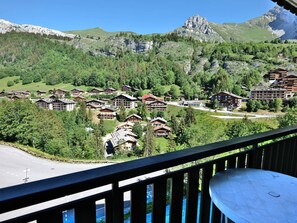A mountain resort with chalet-style buildings, a clear view of the surrounding forest, and a road leading to the property. - Ski-In/Out Studio - Sleeps 4 - Garage - Close to ESF & Chairlift - West-Facing Balcony (Le Grand-Bornand)