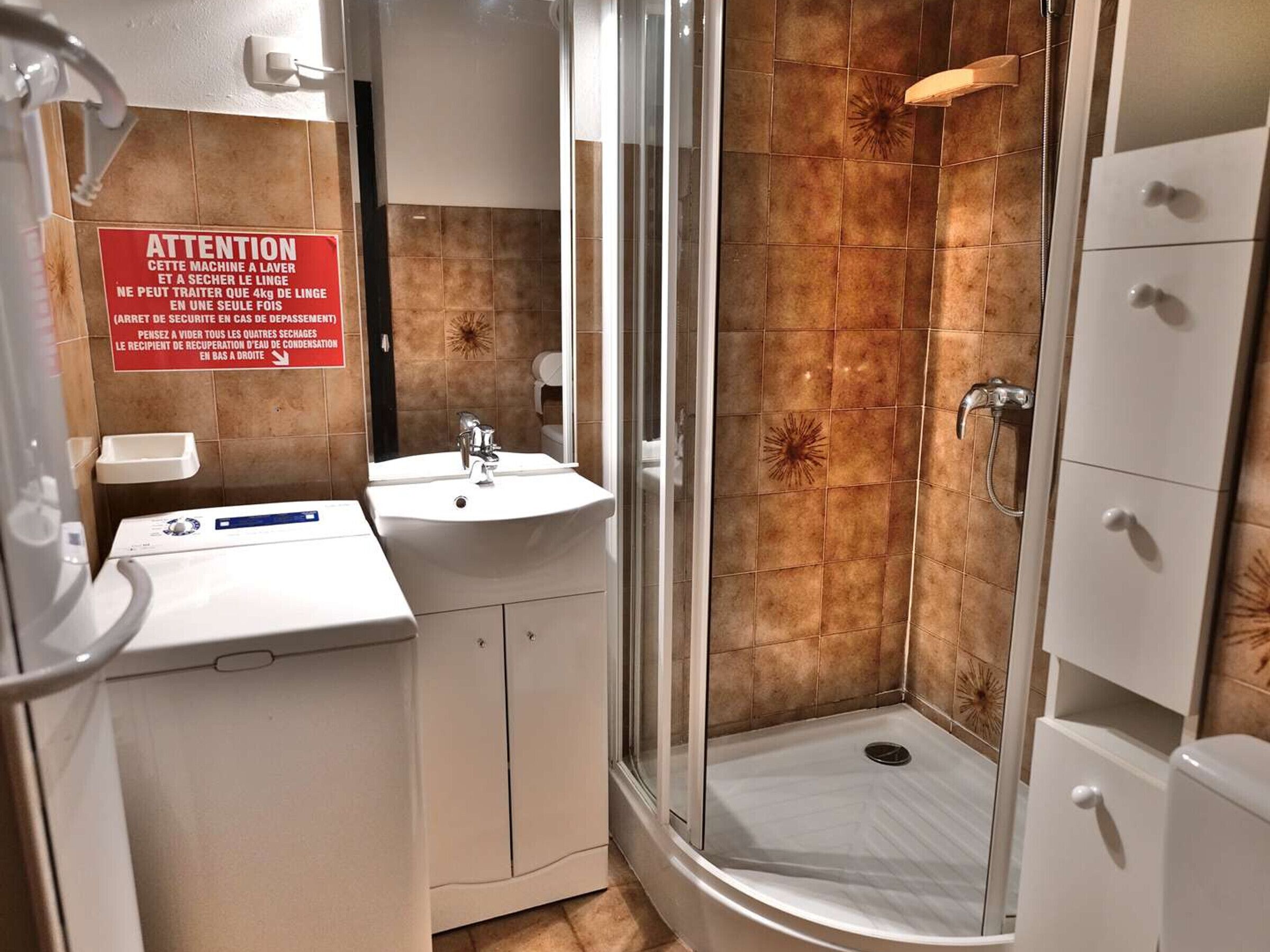 A bathroom with a shower, sink, and cabinets.