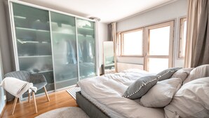 A bedroom with a bed, a chair, a wardrobe, and a window. - 2ndhomes Kamppi Center Apartment 9 (Helsinki)