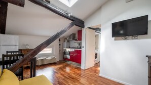 A modern apartment with a kitchen, dining area, and a living room with a sofa.
