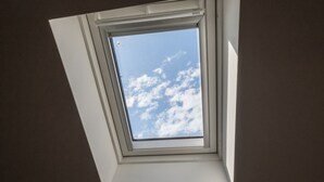 A skylight window with a view of the sky.