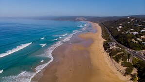 A coastal beach with a road adjacent to it.