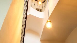 Un escalier muni d’une rampe et d’un luminaire à plusieurs ampoules.