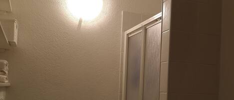 Een kleine badkamer met toilet, douchecabine en handdoekrek.