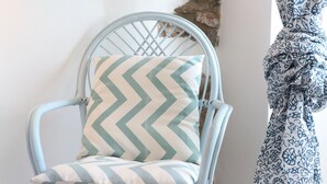 A light blue metal chair with a chevron-patterned cushion. - Room with balcony and beautiful sea view in the old town (Cefalù)