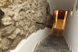A staircase with stone walls on one side and a wooden door at the top. - Suite 58 · Two Ensuite Bedrooms, Sea & Old-Town Balconies, 1 Min to the Beach (Cefalù)
