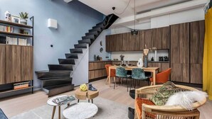 A modern living space with a staircase, dining area, and kitchen.