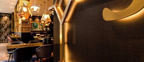 Eine moderne Bar mit Pendelleuchten, einer Bar und Sitzgelegenheiten.