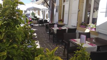 Enjoy a leisurely meal under the shelter of white umbrellas in our charming outdoor café.