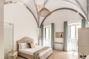 A bedroom with a bed, a bedside table, a mirror, and a wardrobe. - Palazzo Santa Caterina - Una volta (Gallipoli)
